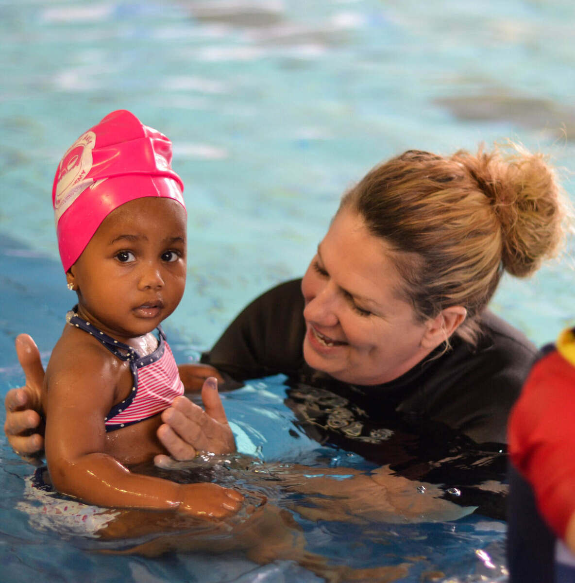 Young child learning to swim in a Kiddies Aqua group lesson