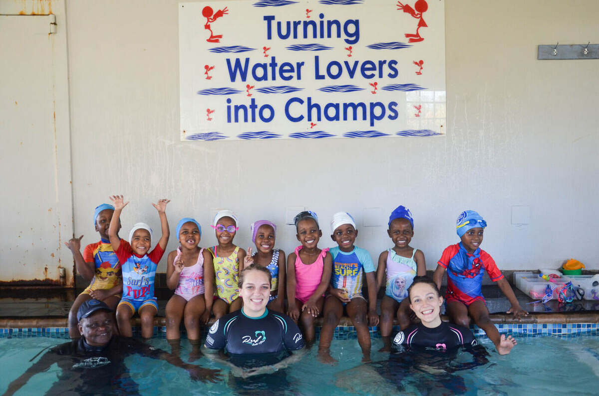 Group of Kiddies Aqua swimmers gathered under the 'Turning Water Lovers into Champs' banner