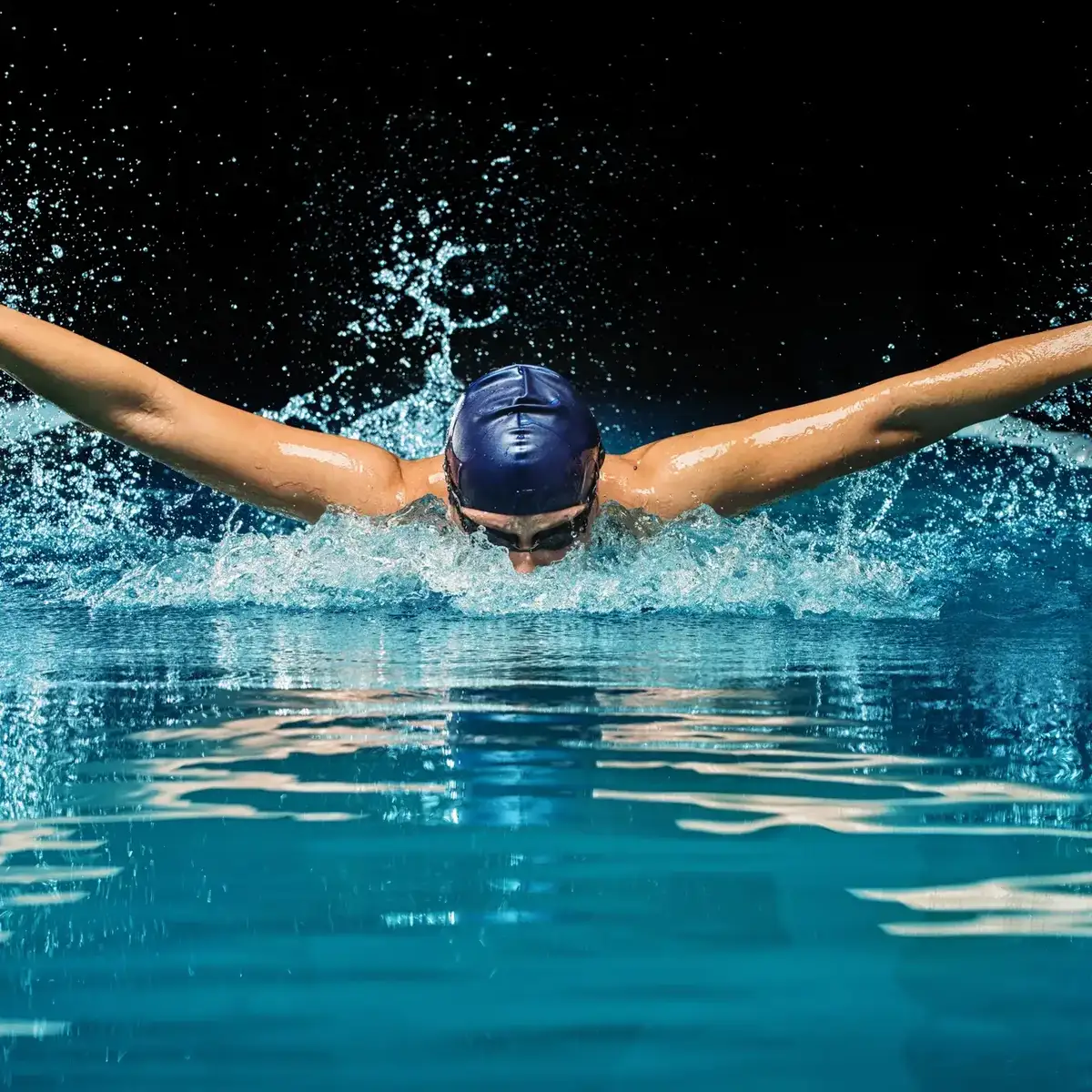 Swimmer powering through a butterfly stroke with strong symmetrical arm extension