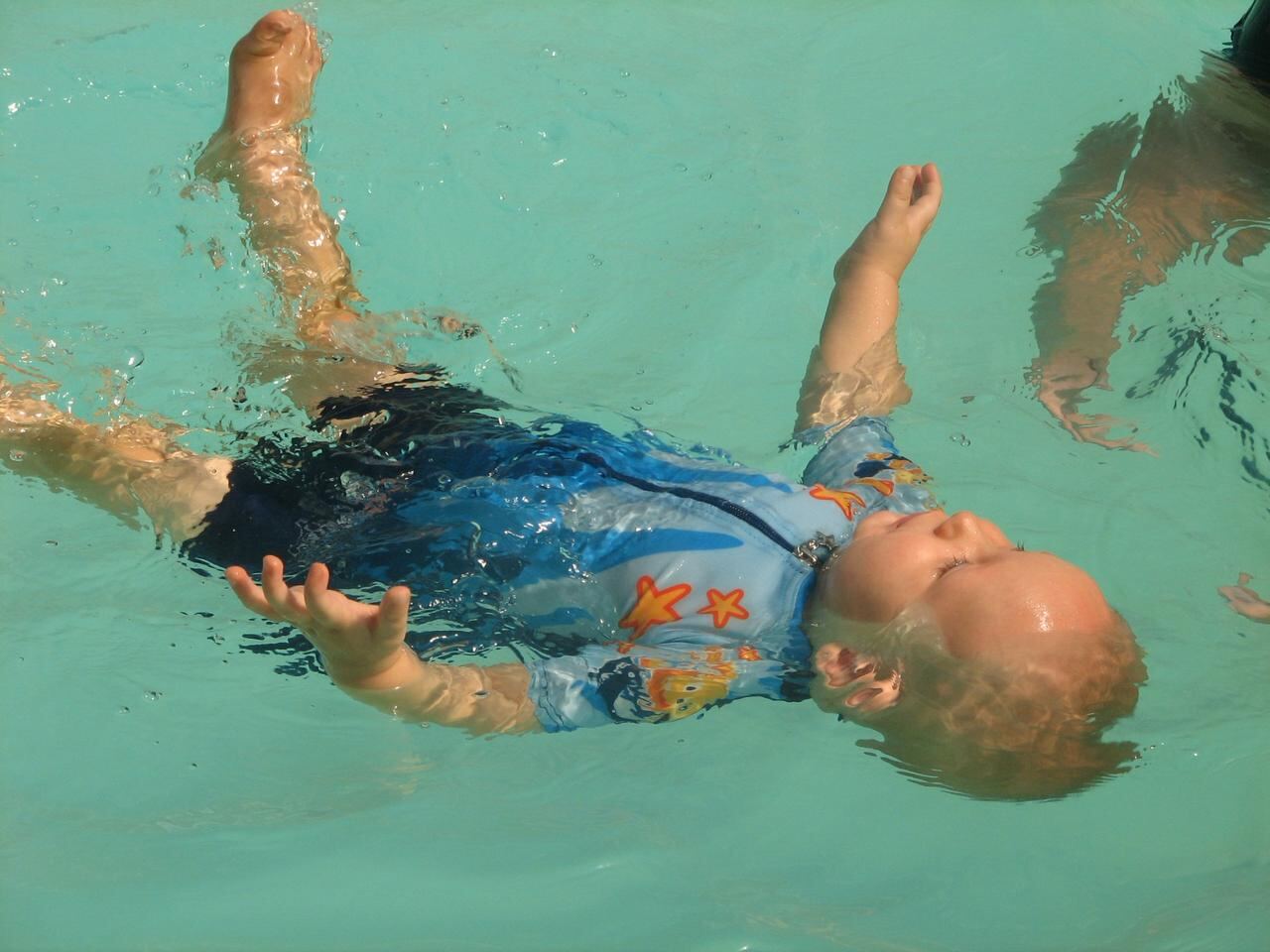 Lizette Botha and Jean Fouace working hands-on in the water with a baby learning the independent back-float self-rescue technique.
