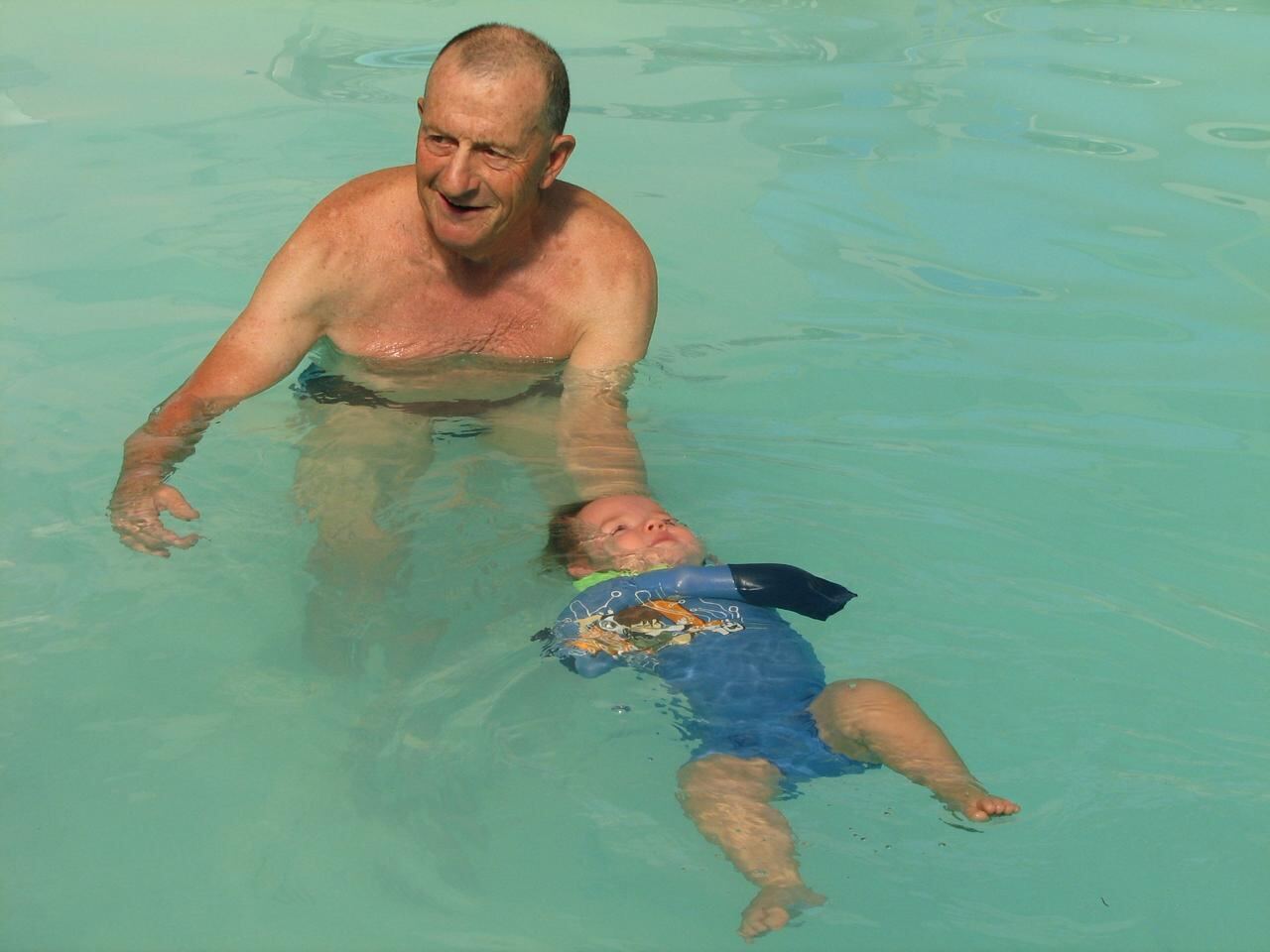 Jean Fouace observing a self-rescue qualification float at a Kiddies Aqua Swimming Academy pool, with Lizette Botha guiding the session.