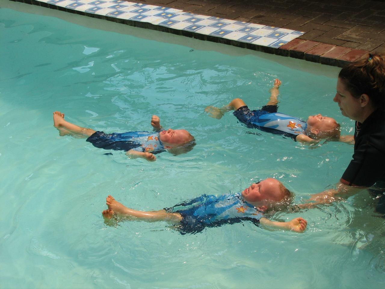 Jean Fouace evaluating an infant's independent back-float at Kiddies Aqua Swimming Academy alongside Lizette Botha.