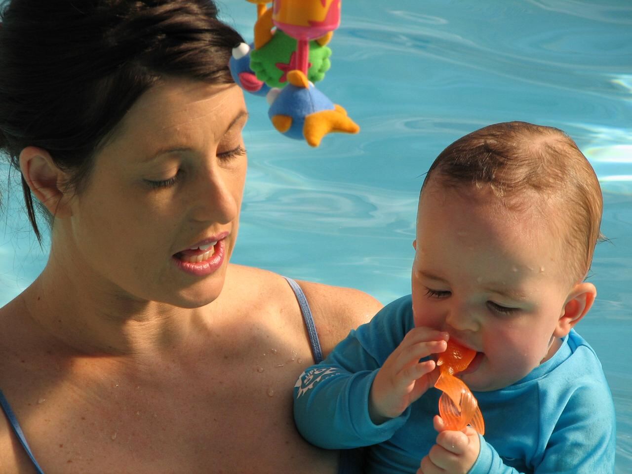 Jean Fouace in the warm-water training pool with a baby, guiding the breath-control reflex at the heart of the Amphibies method.