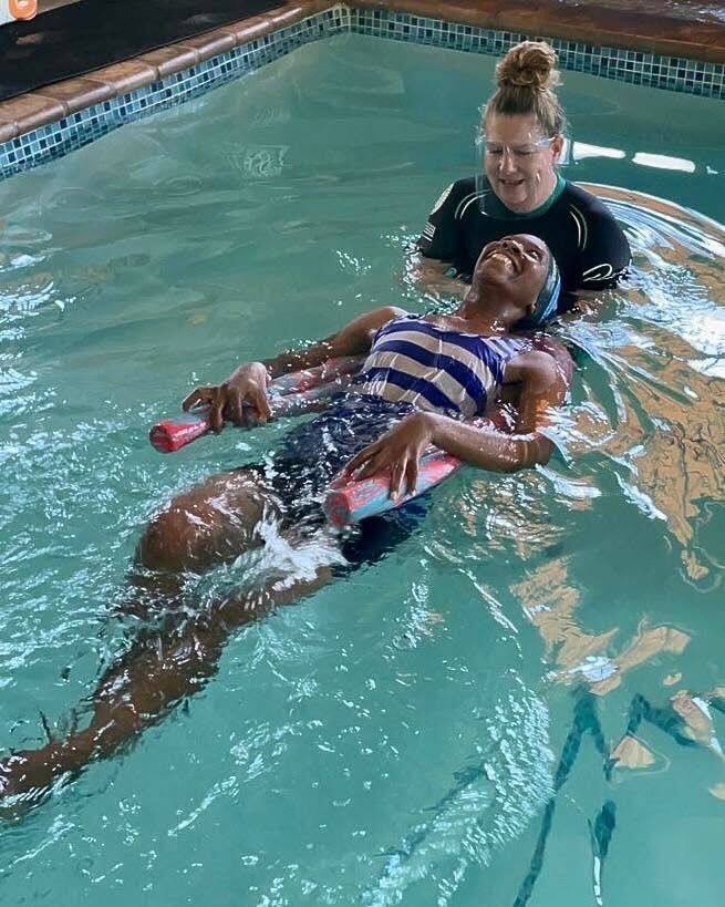 Kiddies Aqua instructor supporting an adult learner through a back-float during an adult swimming lesson