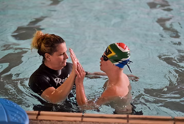Kiddies Aqua instructor giving one-on-one attention to a special-needs learner during a KA-CARE swimming lesson